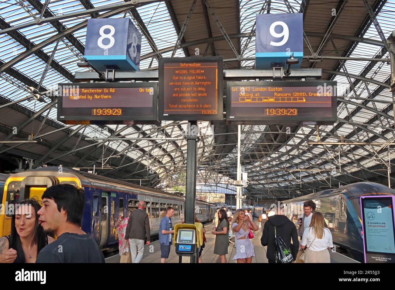 Passengers wait beneath departure boards at Liverpool Lime Street station following signal failure near Warrington causing delays and cancellations Stock Photo