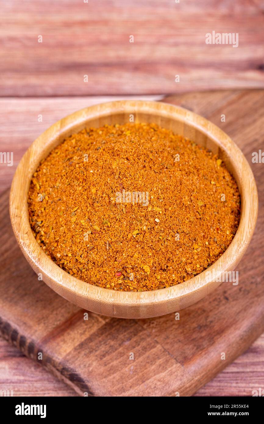 Cajun spice powder on wooden background. Powdered dried cajun in wooden