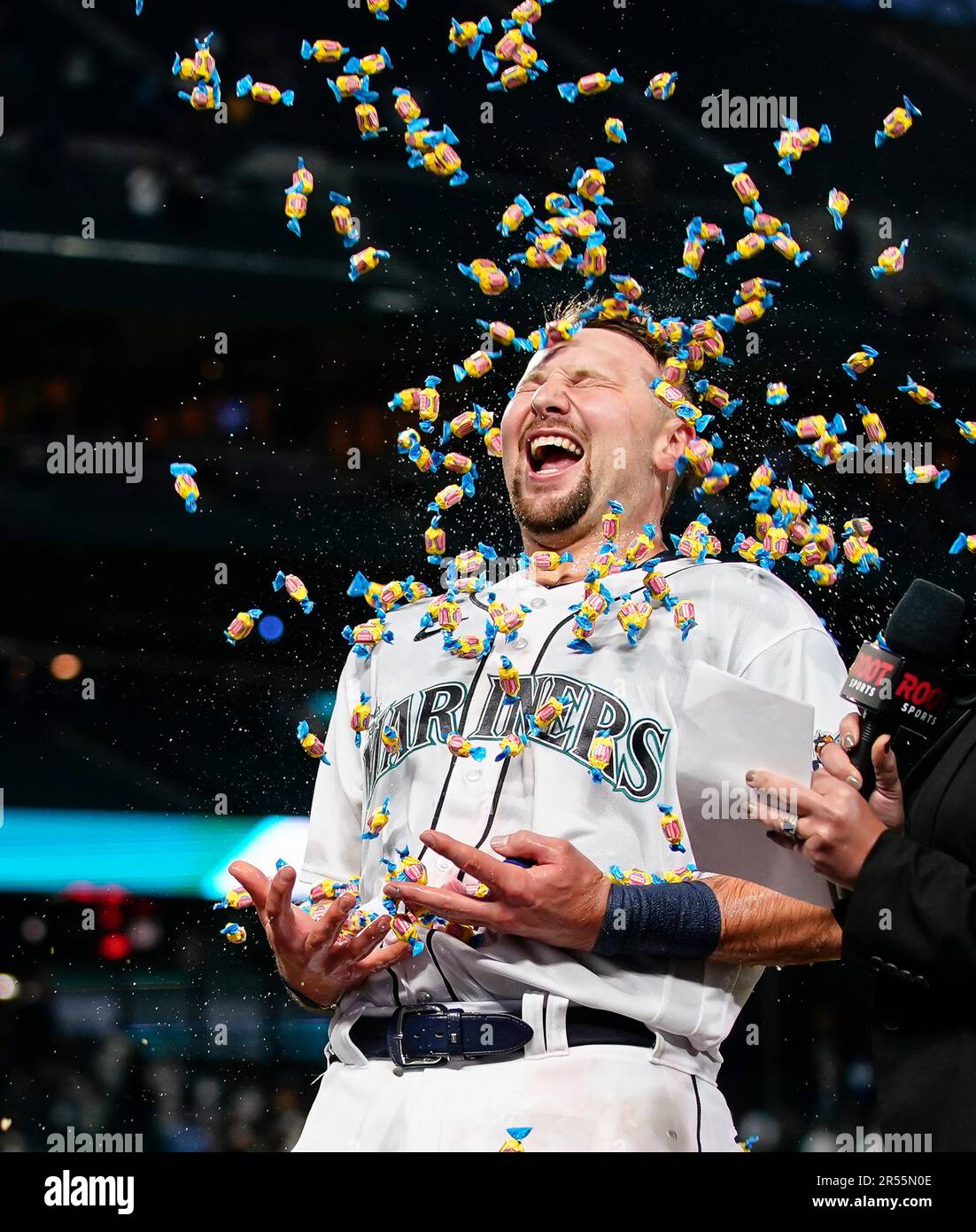 Seattle Mariners' Cal Raleigh laughs as a teammate throws bubble gum at him  while he does a postgame interview after hitting a walk-off single during  the 10th inning to win a baseball