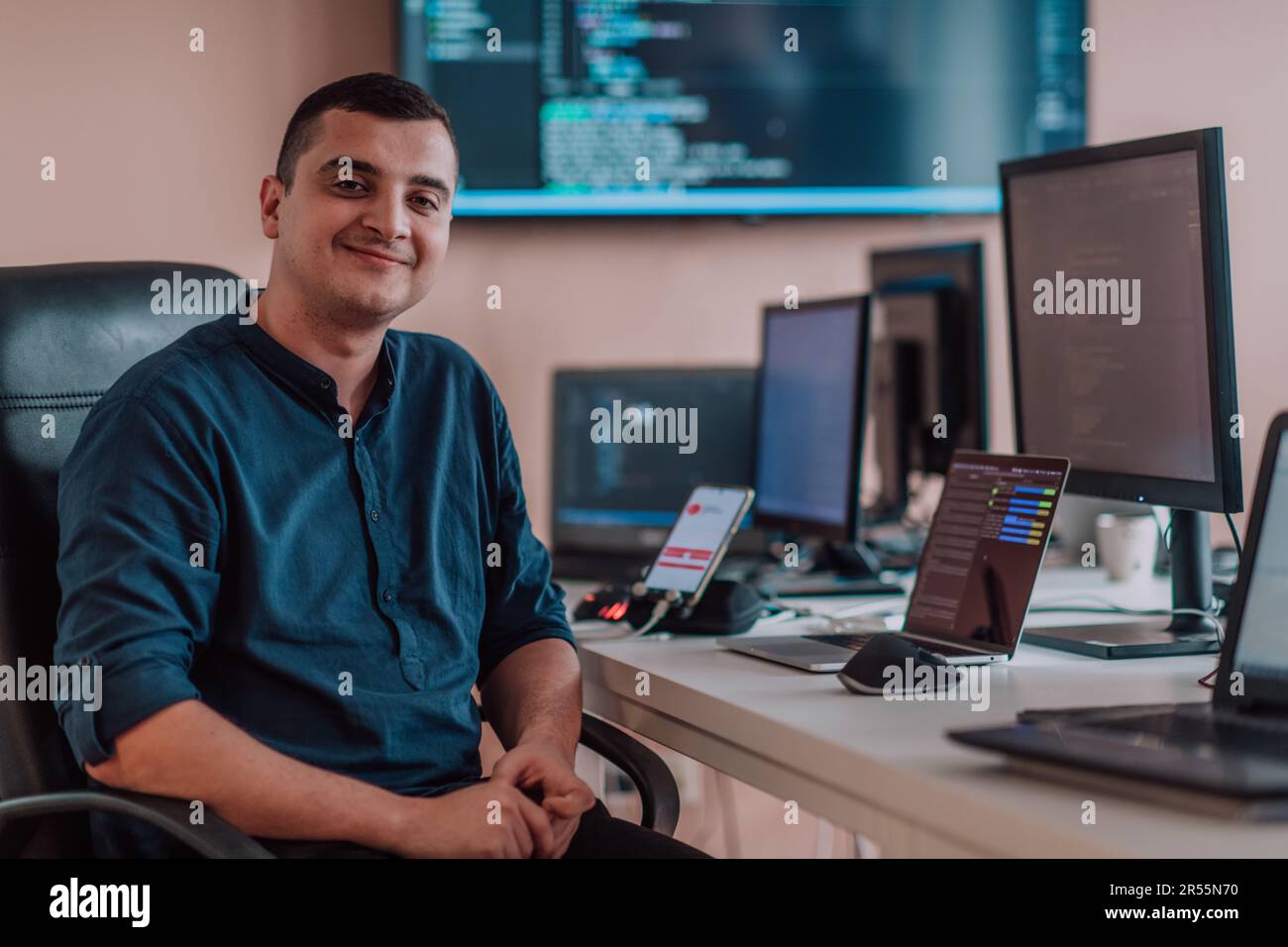 Smartphone Programmer A programmer diligently testing smartphone applications while sitting ...