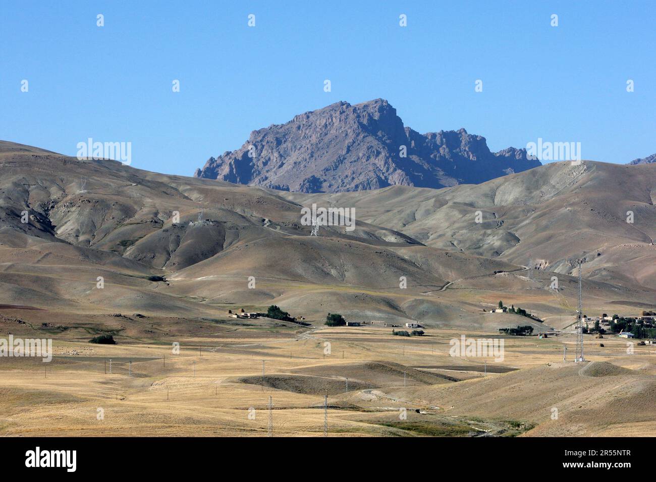 A view of farm land sitting below baren mountains at Cavustepe in the Gurpinar district of Van Province in eastern Turkiye. Stock Photo
