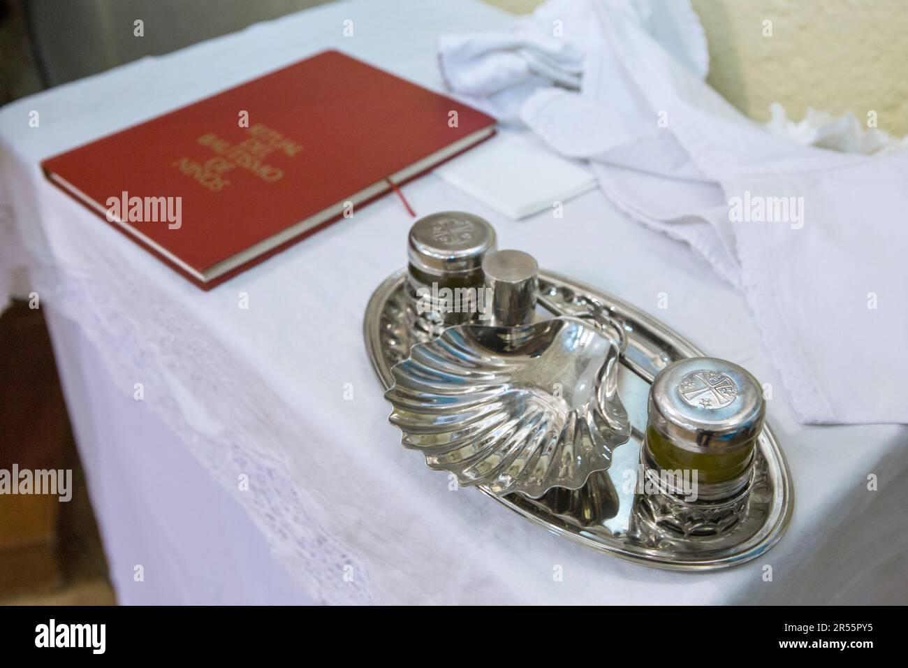 Baptism liturgical objects ready on table at church. Book, manuterge