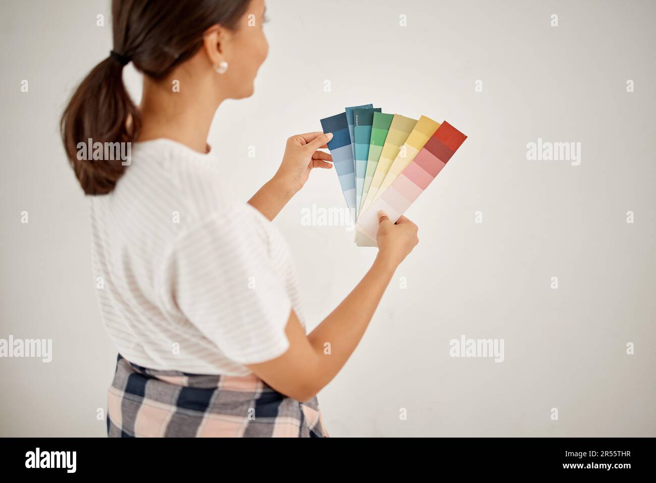 Renovation, woman and wall colours with chart at home with creativity for interior design. Female designer, thinking and colour card for paint for a Stock Photo