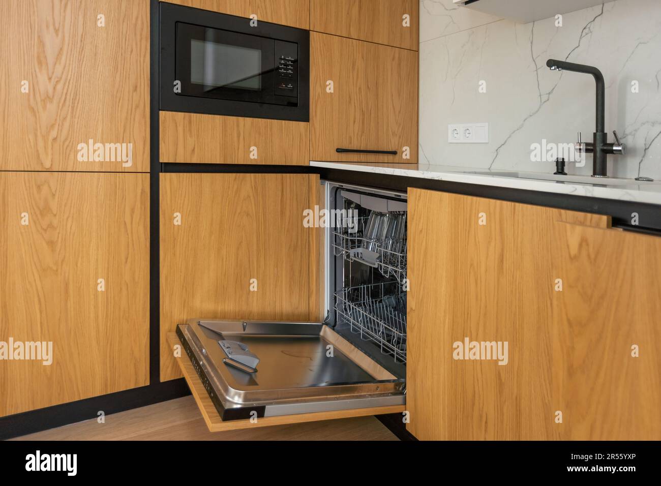 Modern kitchen with empty Builtin dishwasher with opened door
