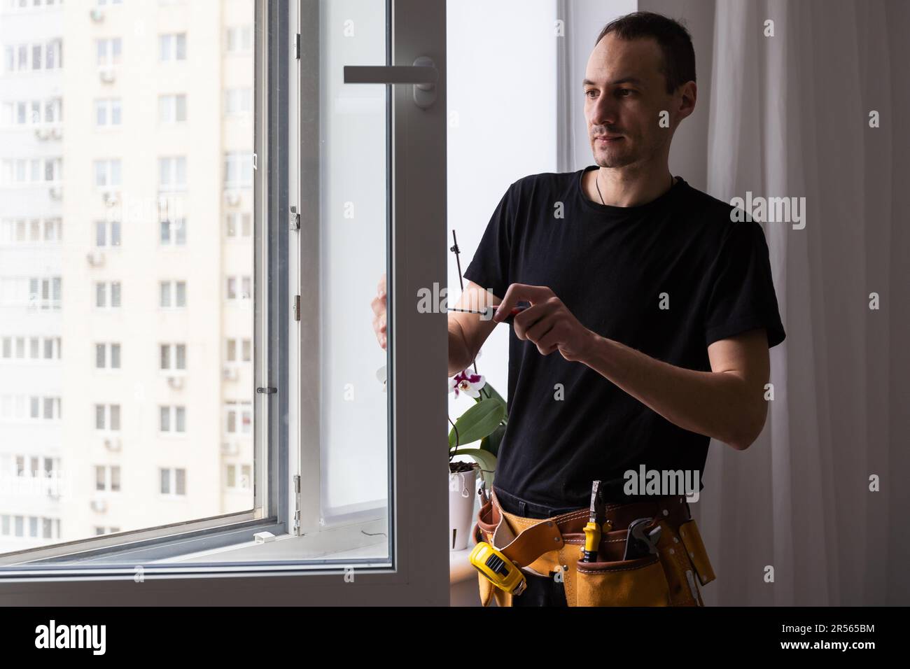 Construction worker installing new window in house Stock Photo - Alamy