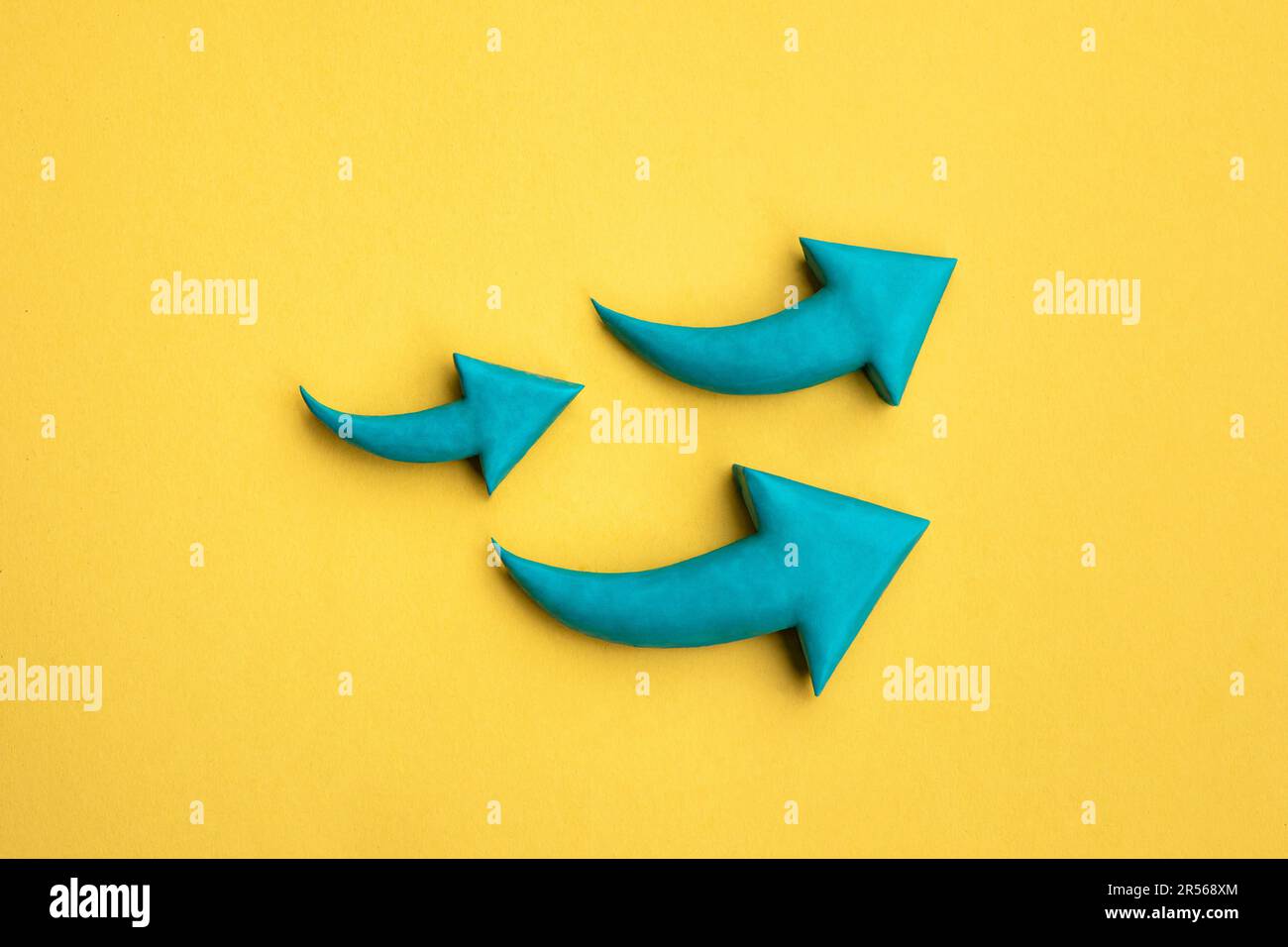 Photo of 3 green arrows made of plasticine pointing up. 3D mockup, arrow sign pointing increasing direction on yellow background. Development concept, Stock Photo