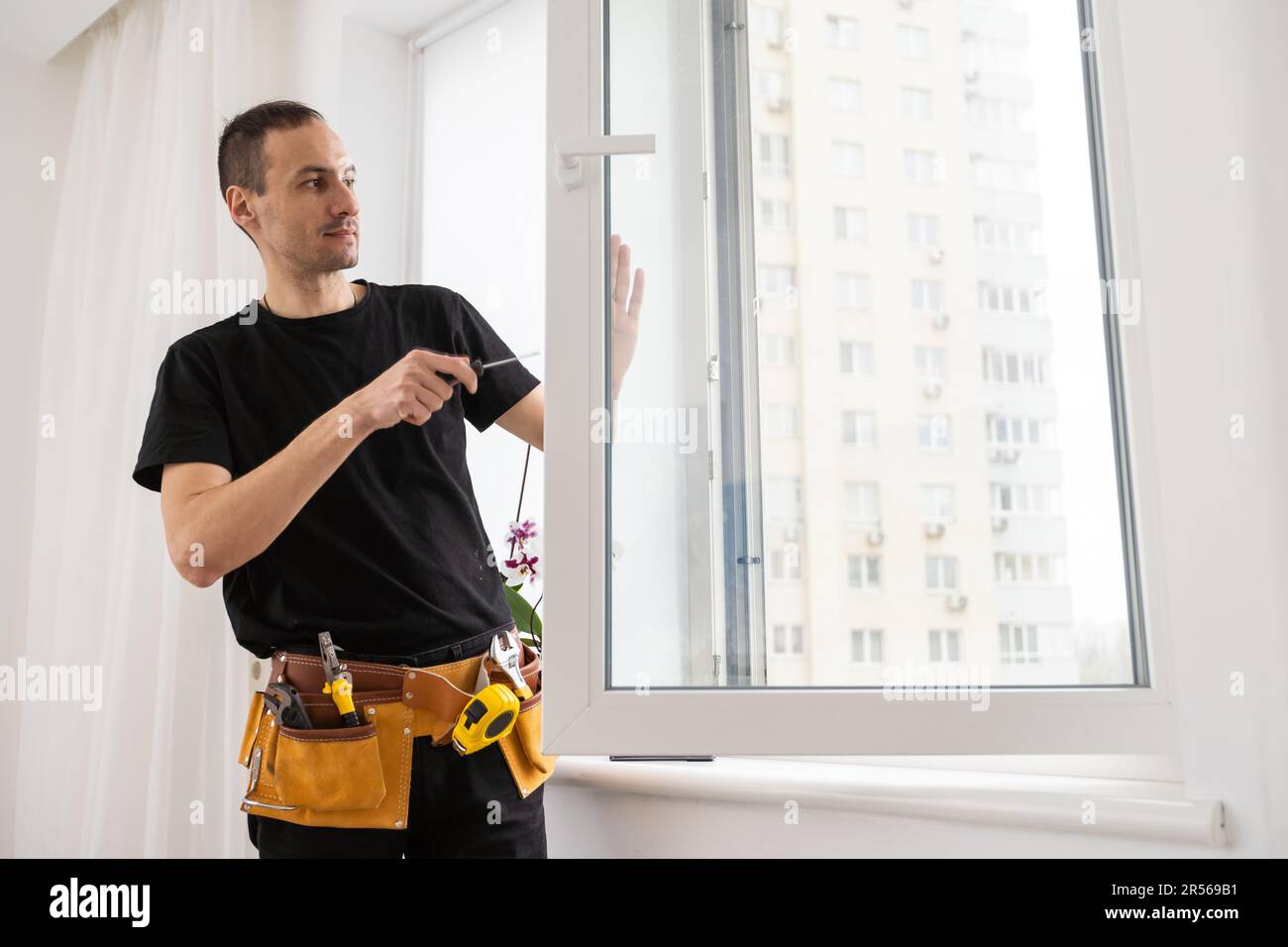 Construction worker installing new window in house Stock Photo - Alamy