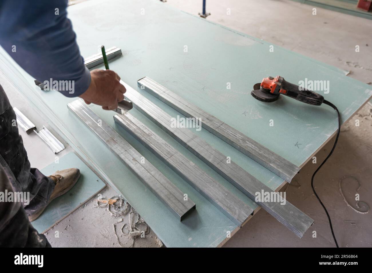 Man assembles profile metal frame for plasterboard ceilings Stock Photo