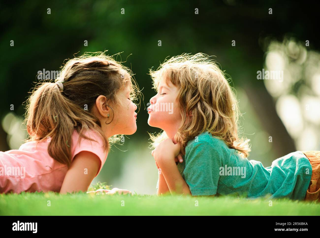 Kids relationships. Cute love. Little children kissing outdoors in park ...