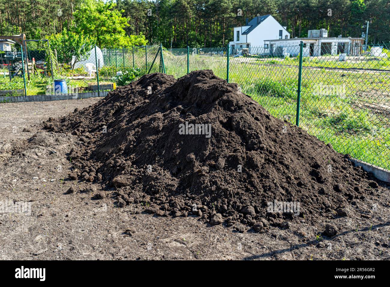 A heap of pure black earth lying in the yard next to the fence Stock