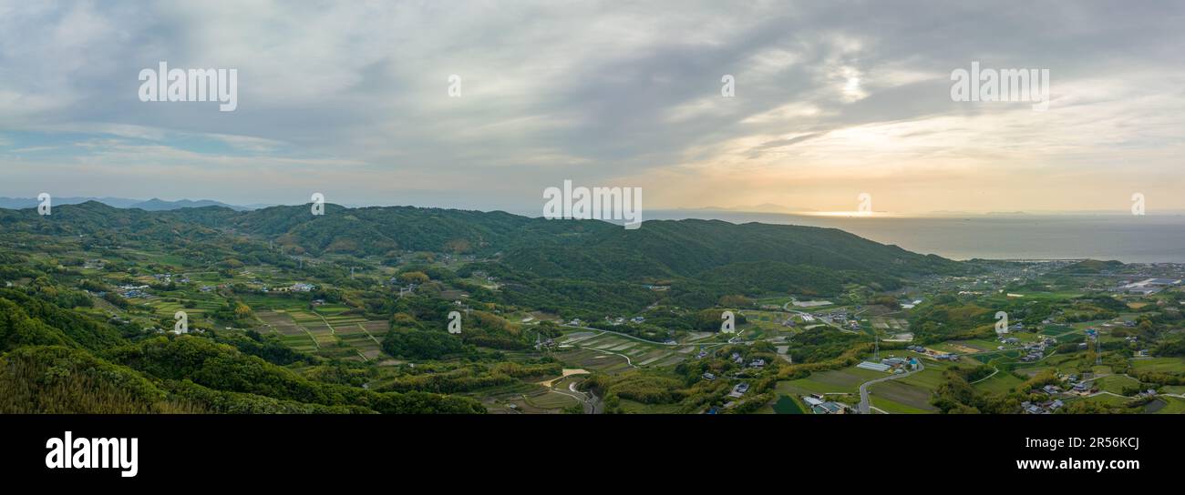Panoramic aerial view of farms and fields in green coastal landscape Stock Photo