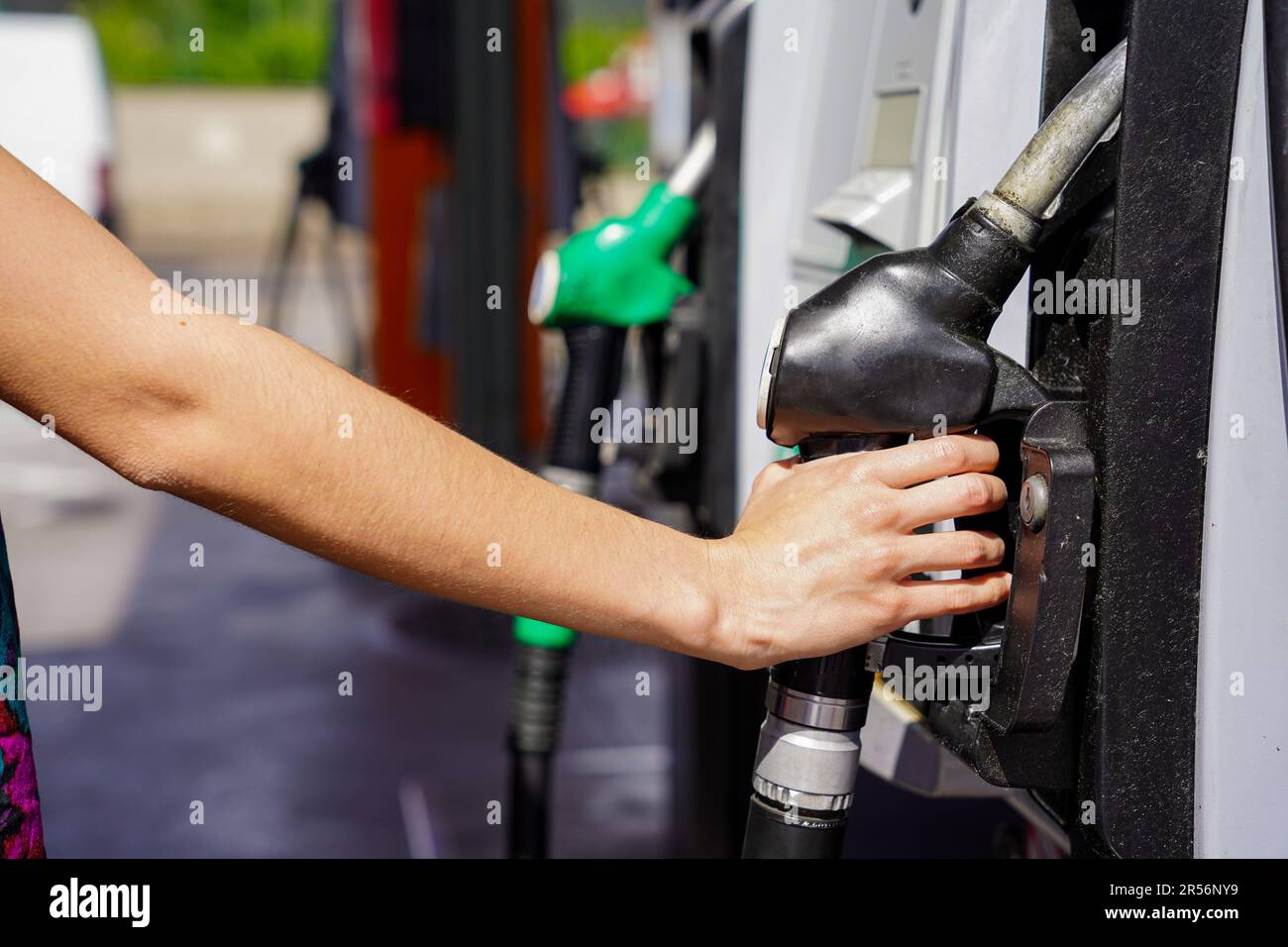 Refueling the car at a gas station fuel pump. An unrecognizable woman