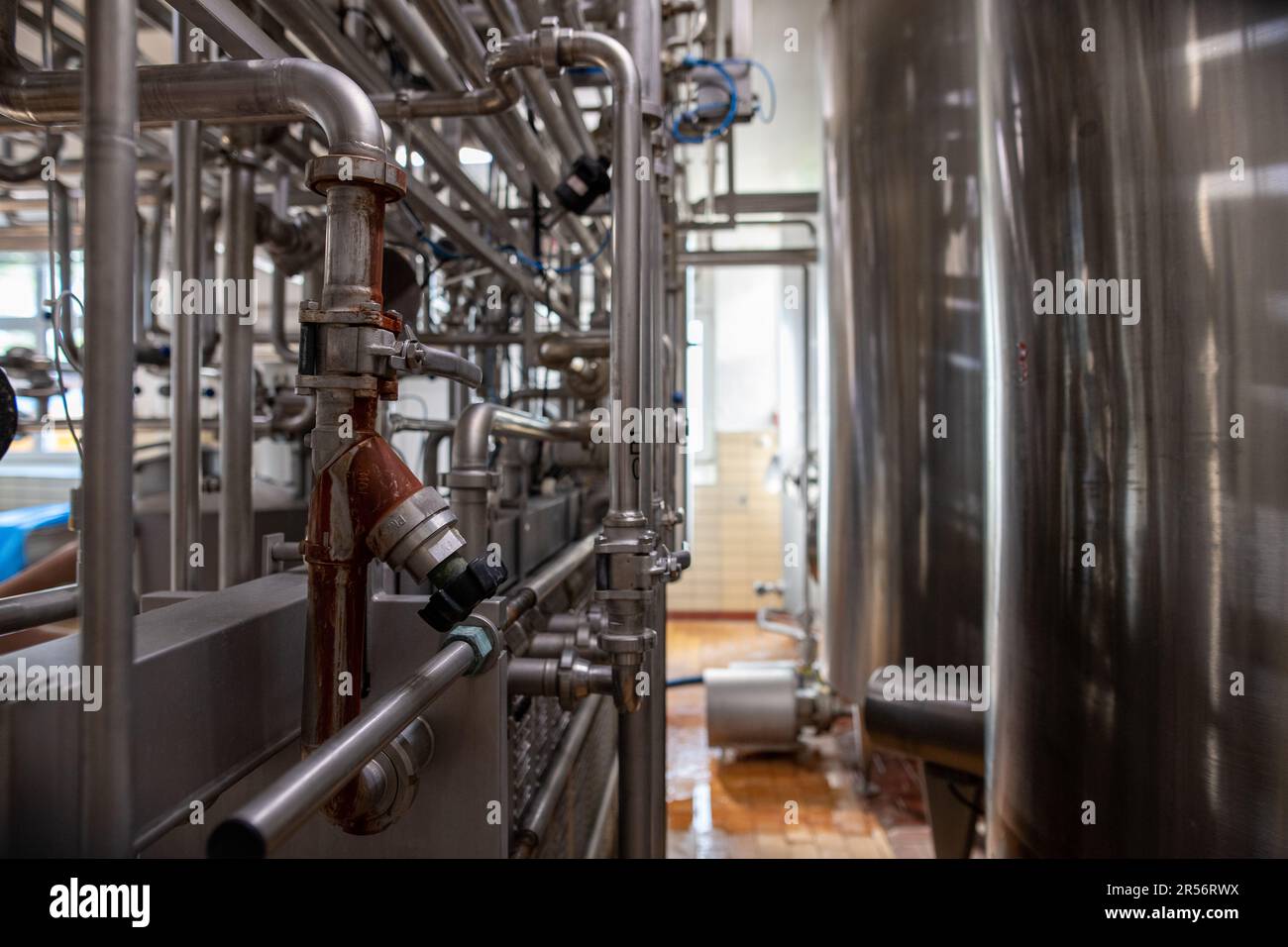 Interior of a modern manufacture with stainless steel tanks and pipes ...