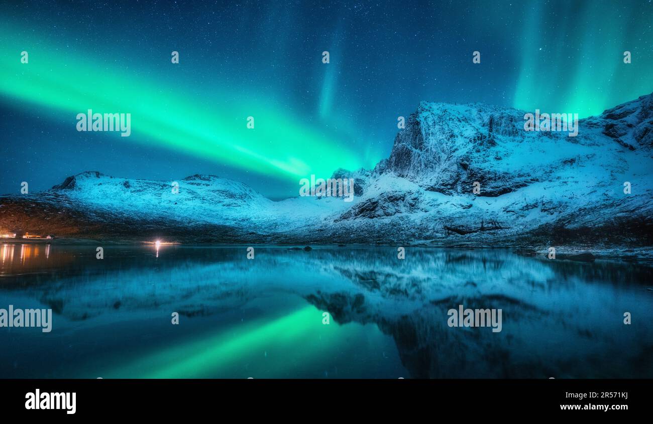 Northern lights over snowy mountains, sea, reflection in water Stock ...