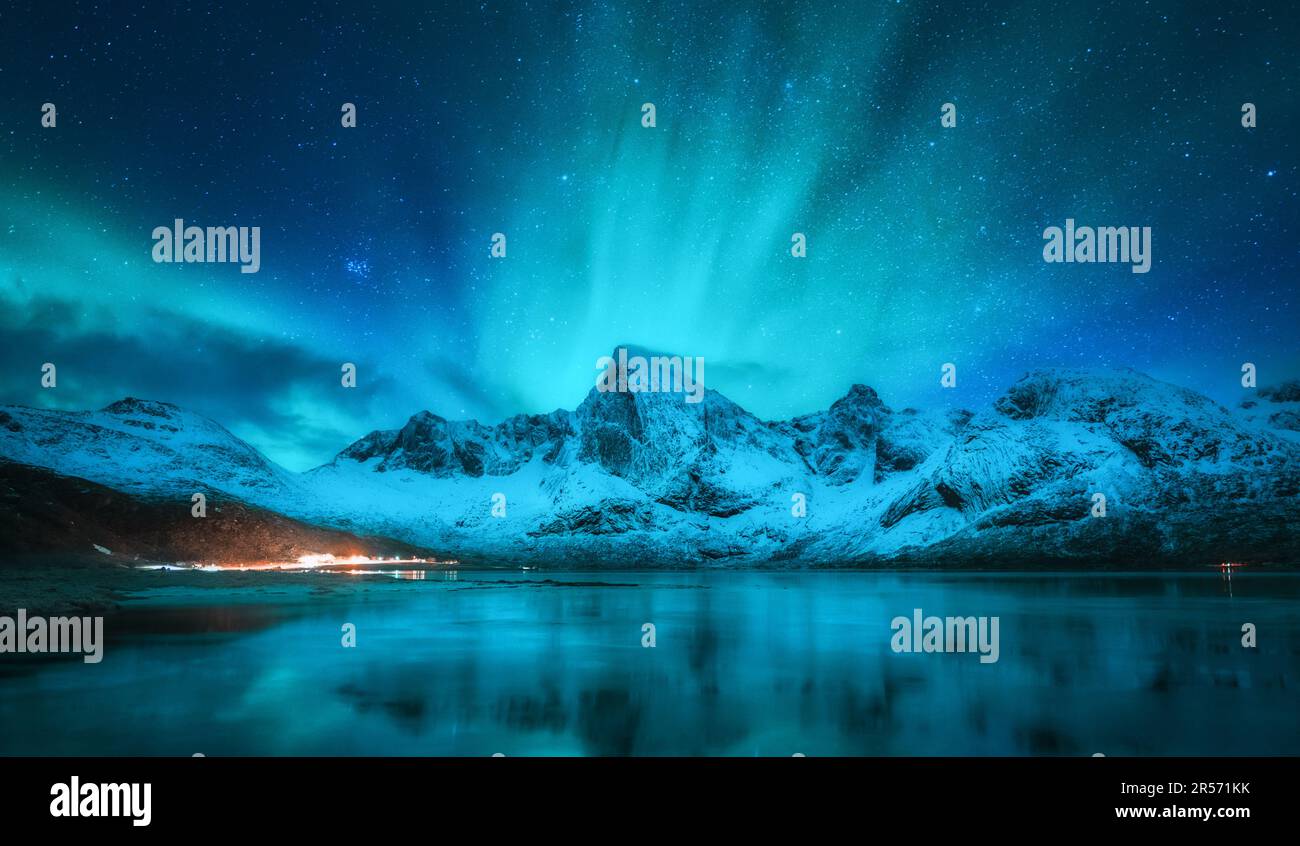 Northern lights over snowy mountains, sea, reflection in water Stock ...