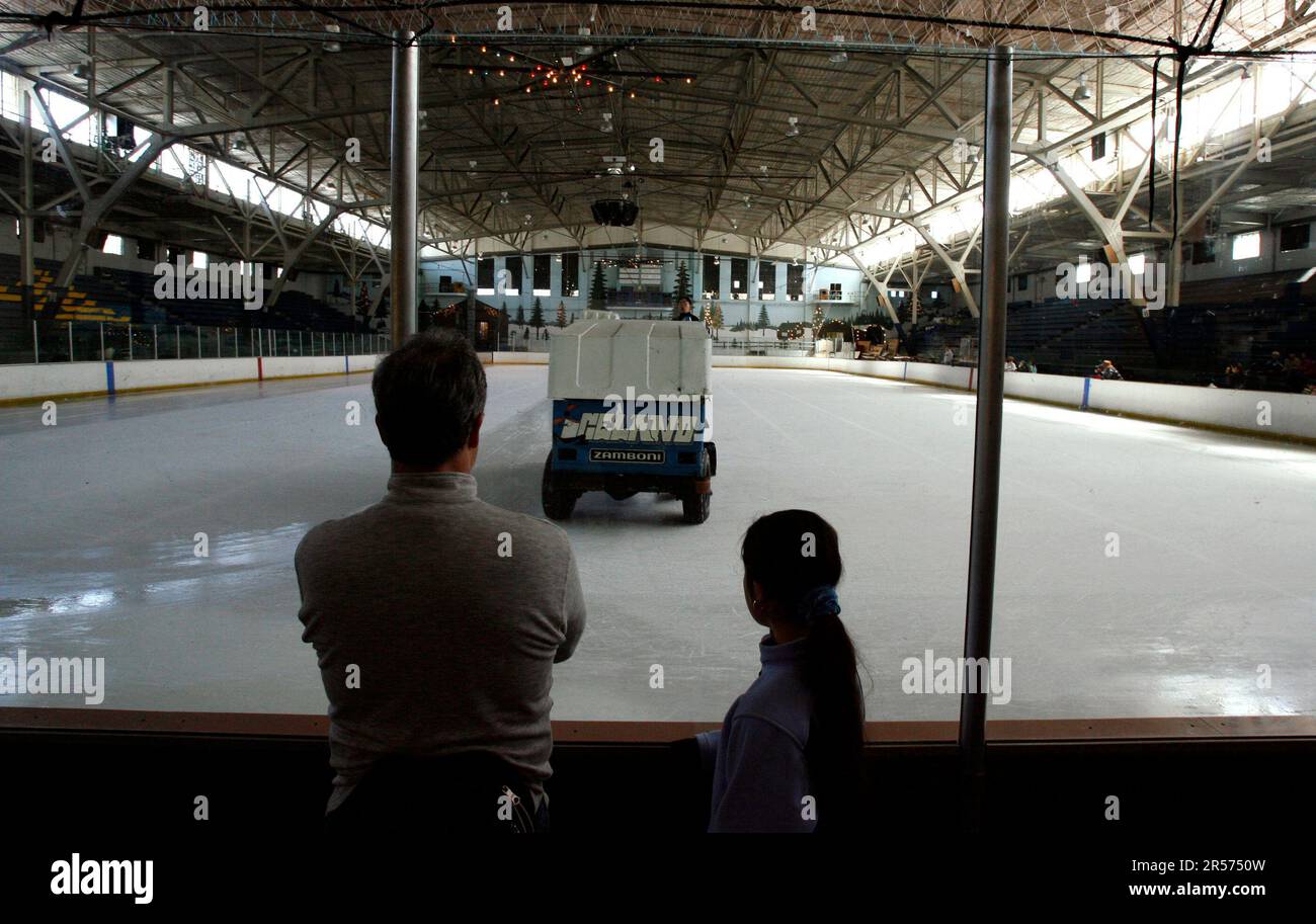 Scott North and his daughter Naomi watch the Zamboni resurface the ice