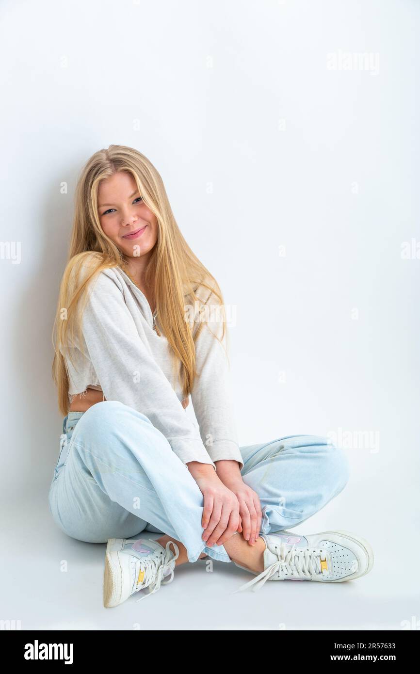 Portrait Of A 19 Year Old Blonde Woman Sitting Crossed Legged On The