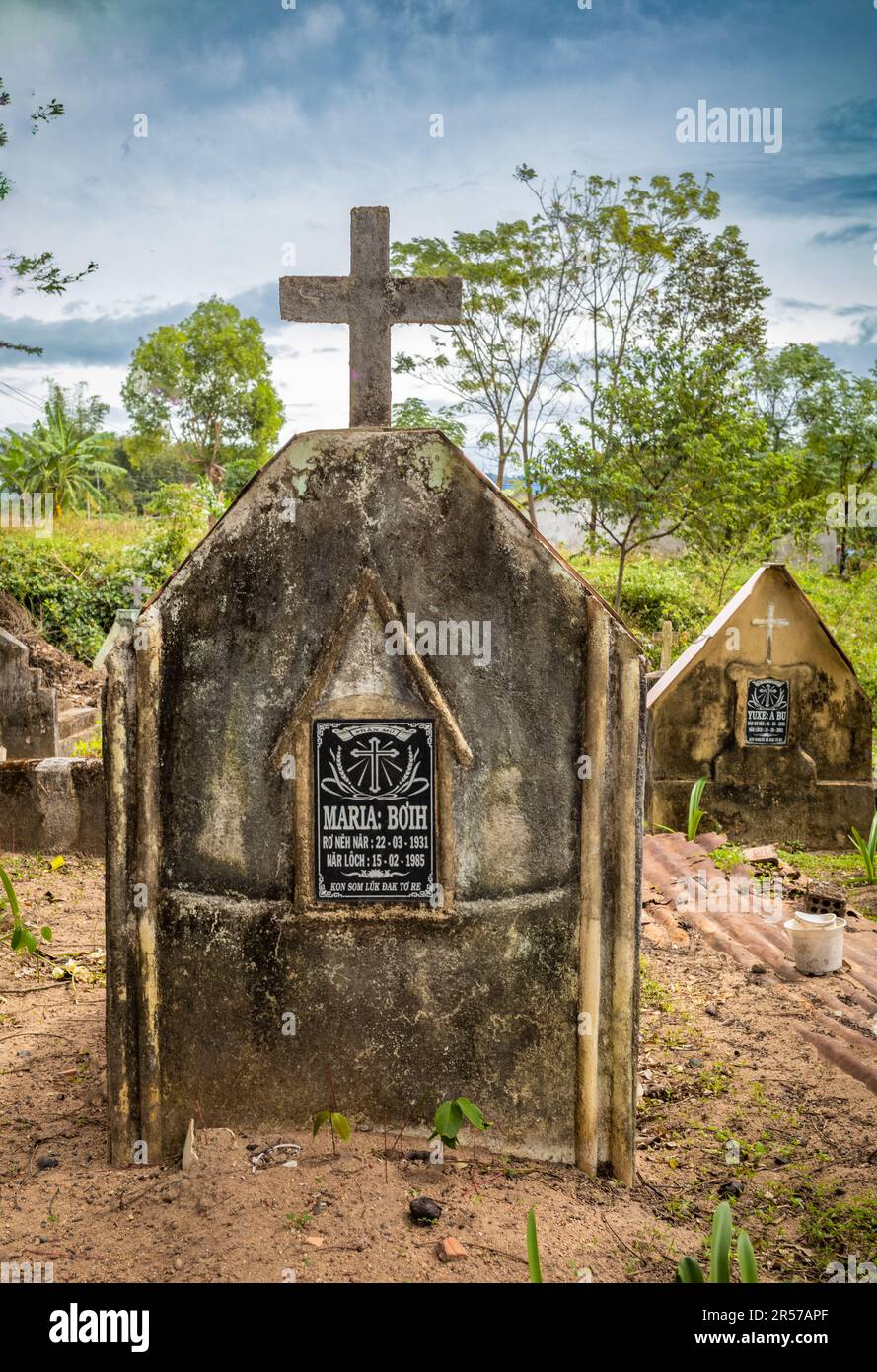 Graves in a Catholic cemetary opposite Kon Xom Luh Catholic Church, Kon Ray, Kontum, Vietnam. Poorer graves are simply covered with rusting oil drums. Stock Photo