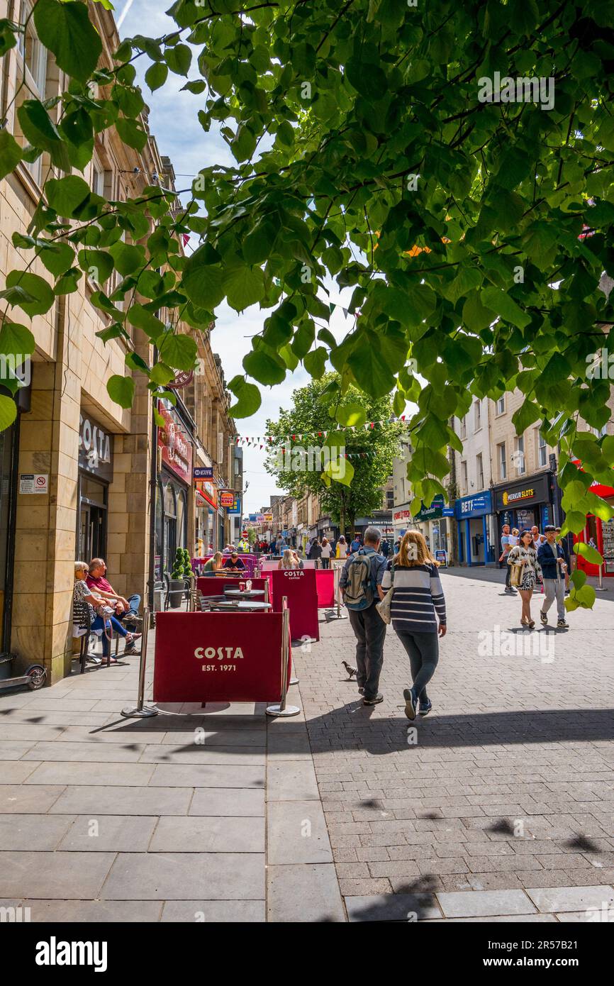 Costa coffee cafe customers and shoppers enjoying spring sun in the