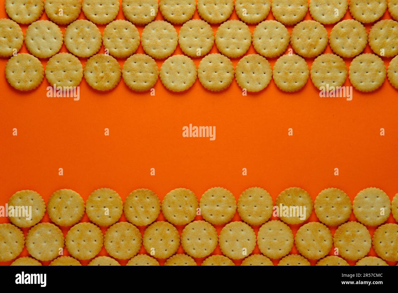 Crackers in repeating rows against a plain background. Top down view. Stock Photo
