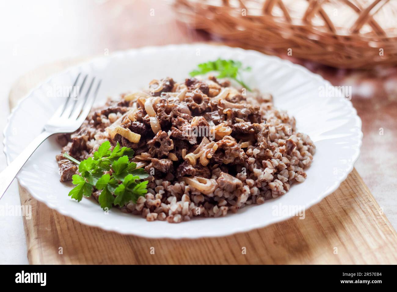 Spring Morel mushrooms stewed in sour cream, served with buckwheat on white plate Stock Photo