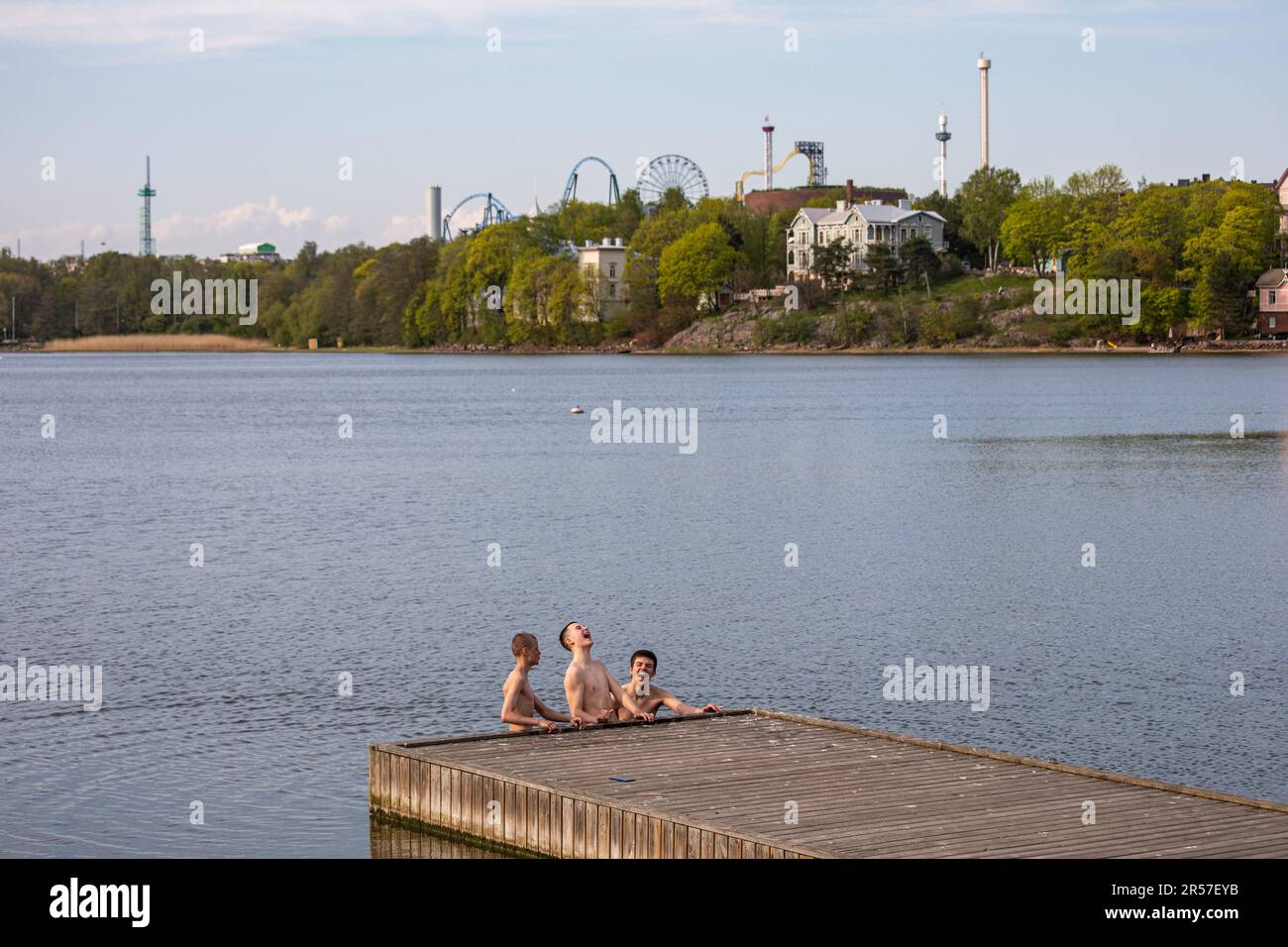 Teenage boys standing in cold water in Töölönlahti Bay, Helsinki, Finland Stock Photo
