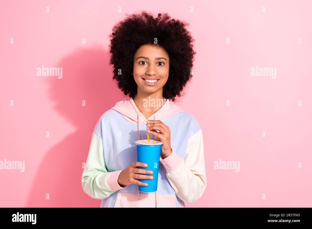 Photo of cute pretty little child dressed hoodie watching movie drinking coca cola coke pepsi isolated pink color background Stock Photo