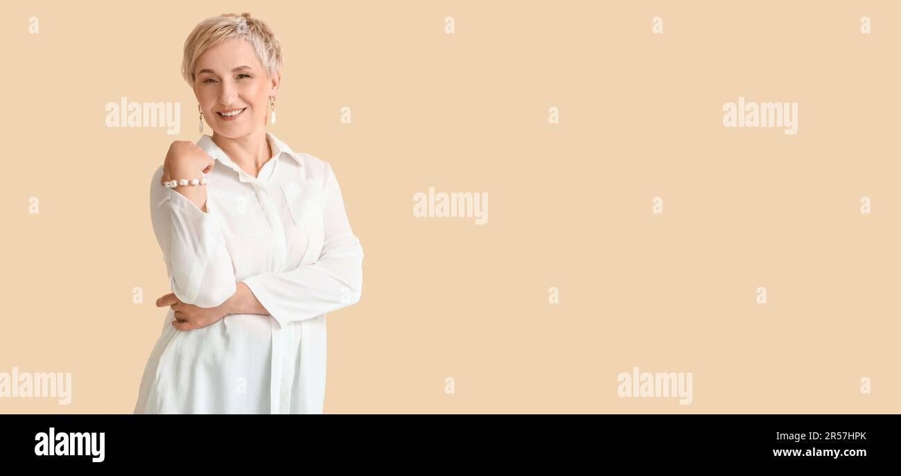 Beautiful mature woman on beige background with space for text Stock ...