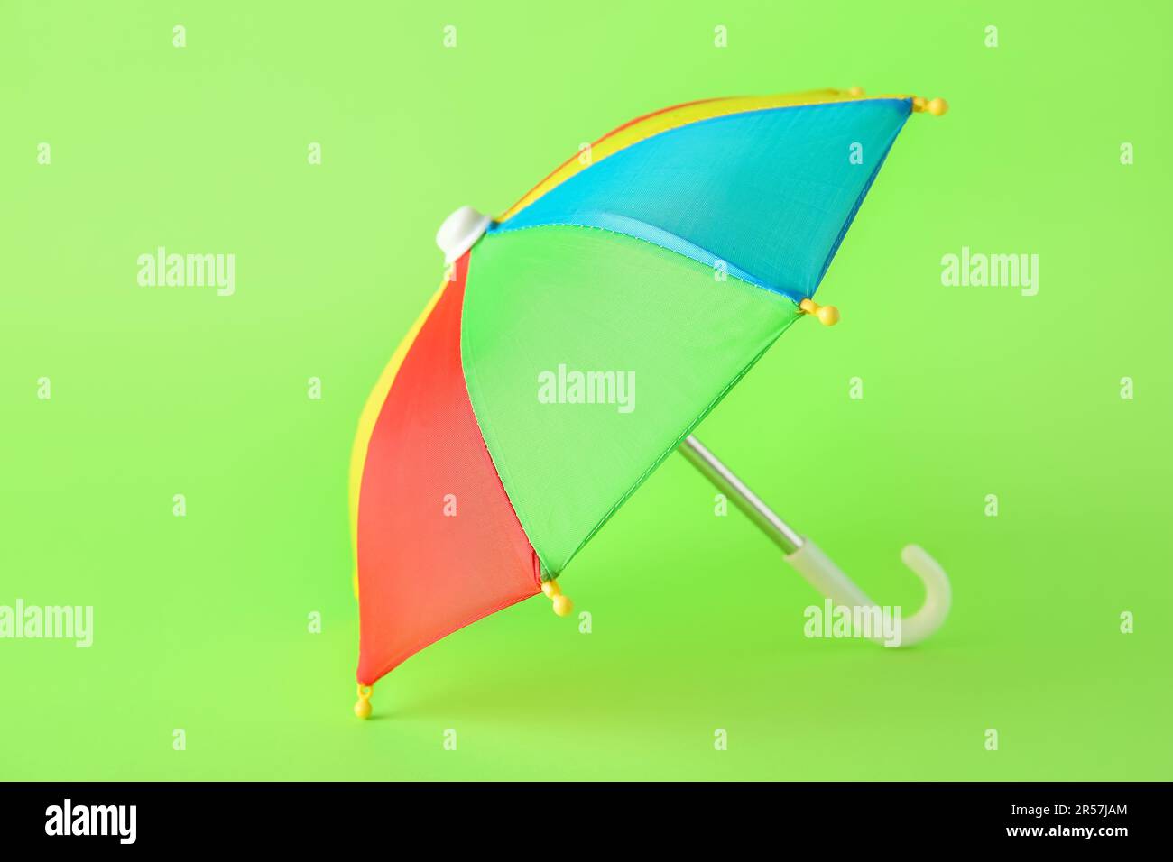 Mini colorful umbrella on green background Stock Photo