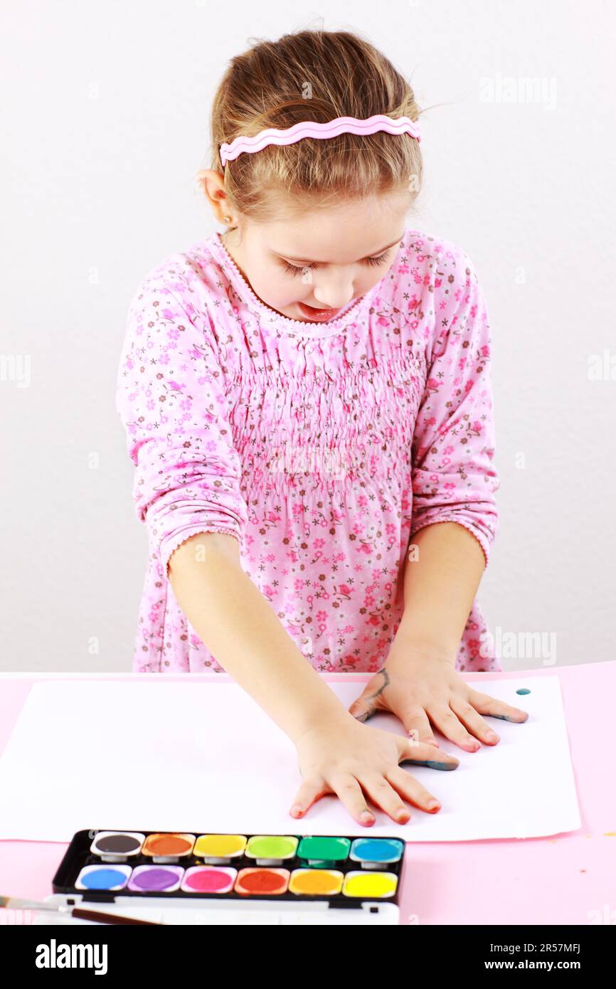 Cute little girl painting with watercolor Stock Photo - Alamy