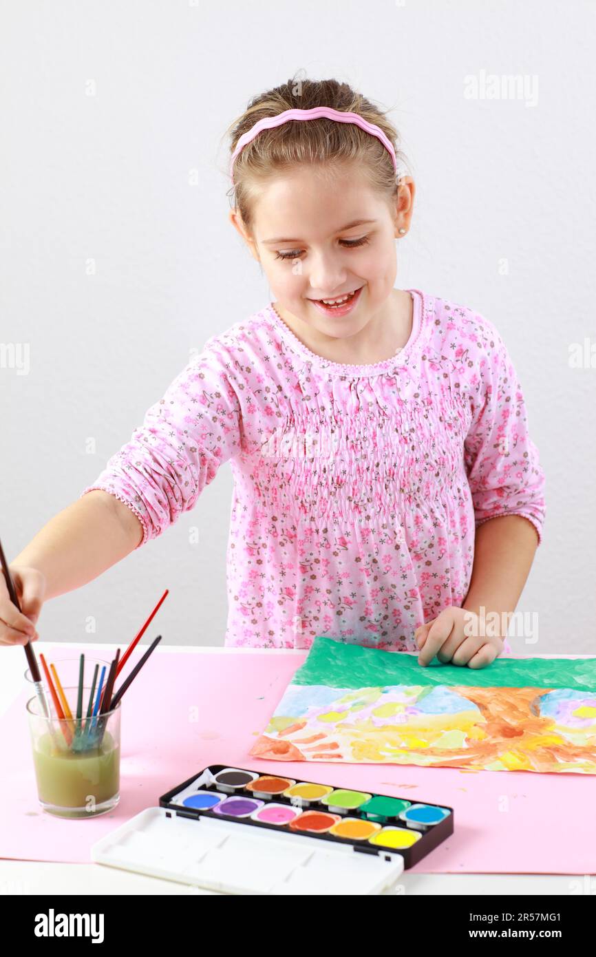 Cute little girl painting with watercolor Stock Photo - Alamy