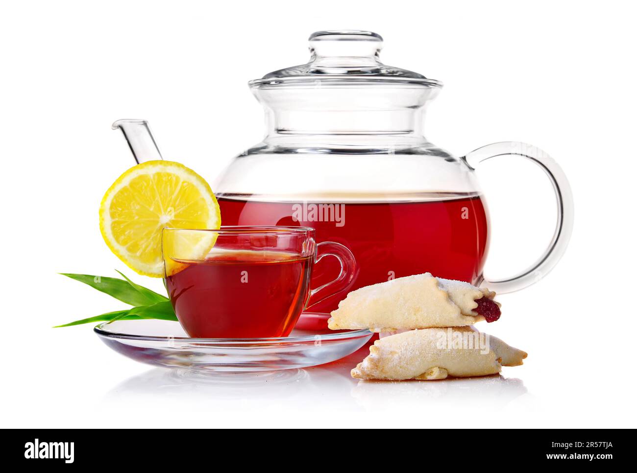 Teapot and cup of black tea with crescent and lemon slice isolated on white background Stock Photo