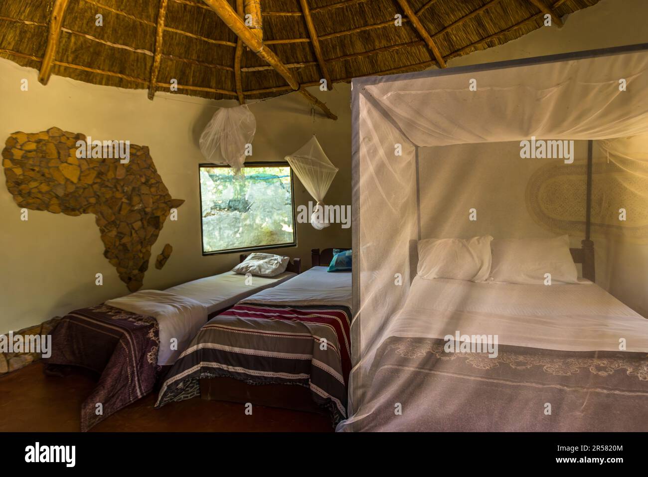 Bedroom in the roundhouse of Kutchire Lodge. The beds are all equipped with mosquito nets. In the tree houses of Kutchire Lodge you are close to the Big Five day and night. Malawi Liwonde National Park Stock Photo