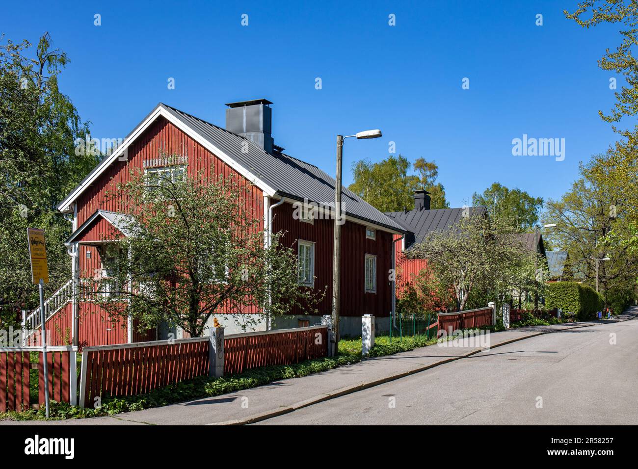 Residential wooden buildings against clear blue sky on a sunny late spring day at Siamintie in Toukola district of Helsinki, Finland Stock Photo
