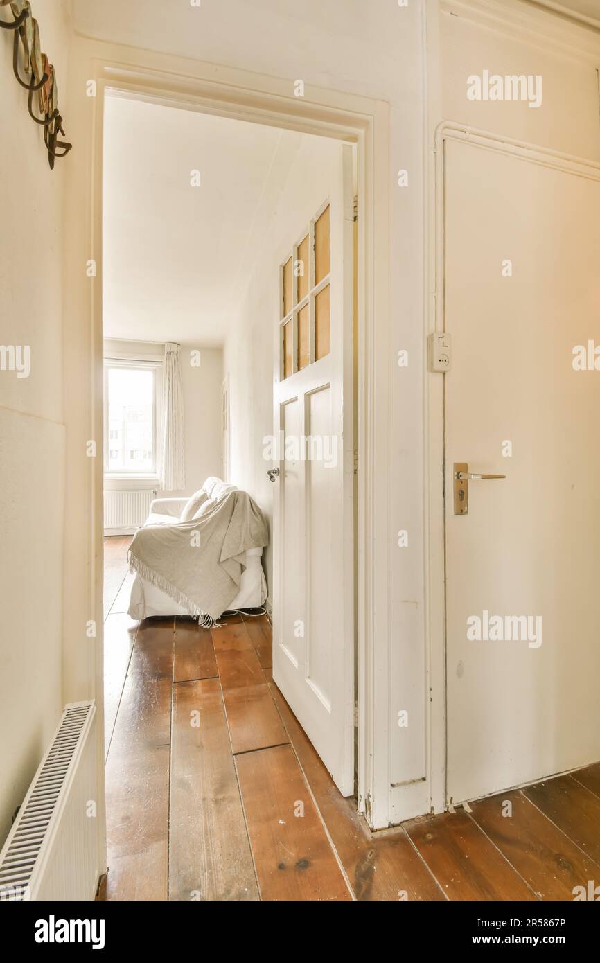a room with wood flooring and white walls, an air condition heater is ...