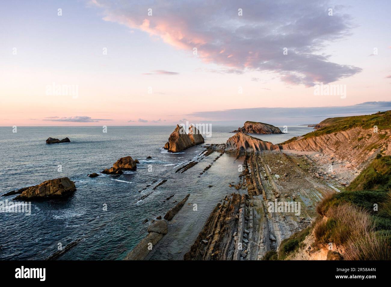 Abrasion platform, flysch and cliffs in Costa Quebrada (Cantabria, Spain). Beautiful seascape at dusk by the Cantabrian Coast Stock Photo