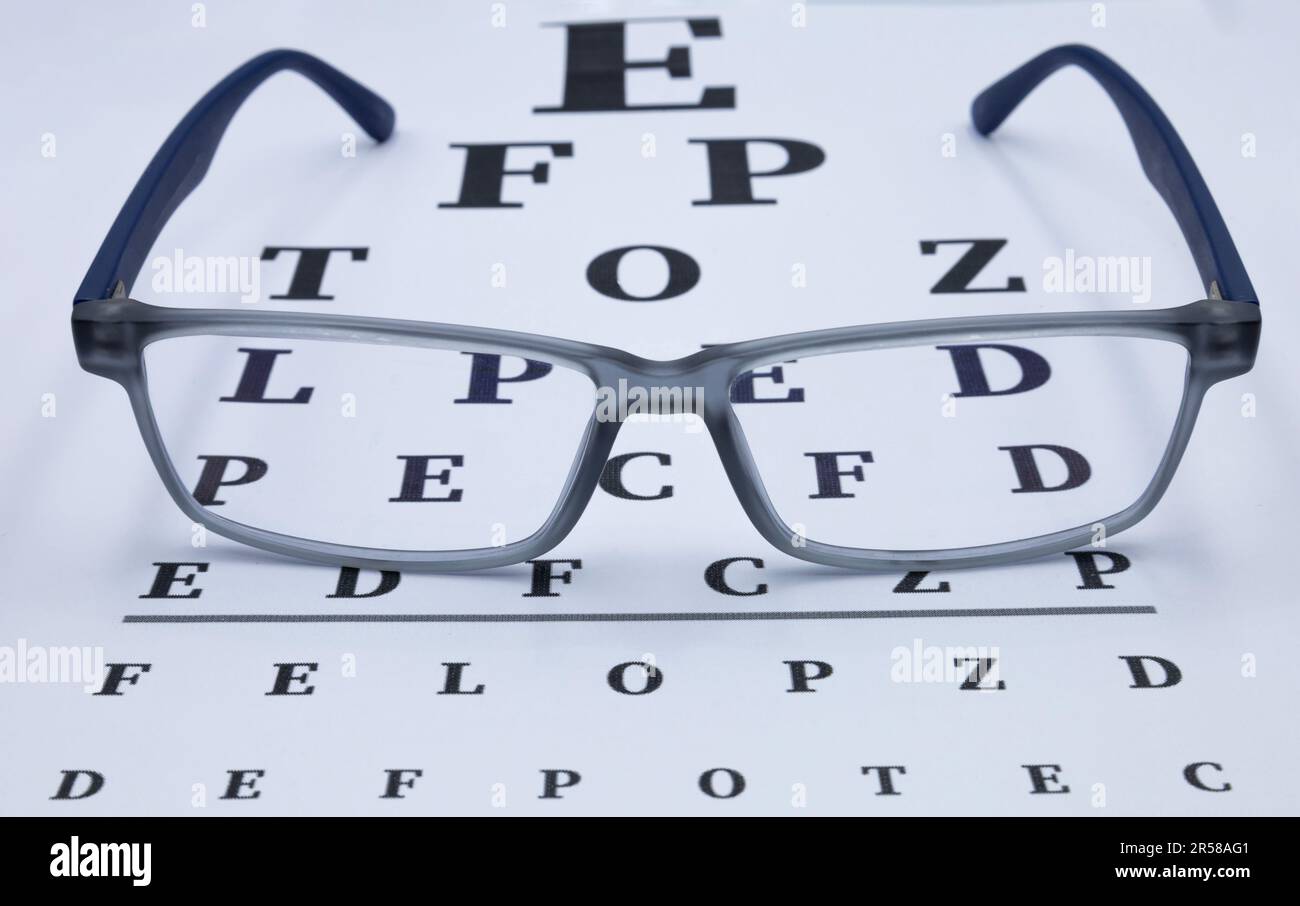 Eyeglasses with eye test table. Optical store, glasses selection, eye test, vision examination at optician Stock Photo