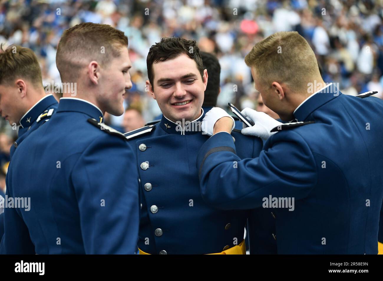 A Cadet gets help with his shoulder boards after graduation ceremonies
