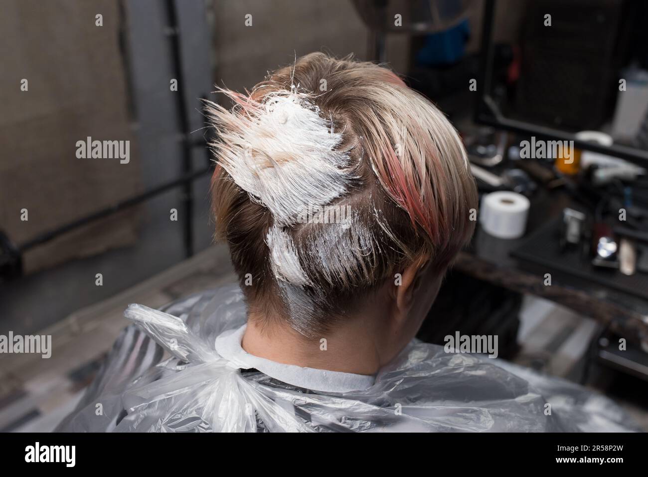 customer head in white paint professional hair dyeing process in hairdresser or