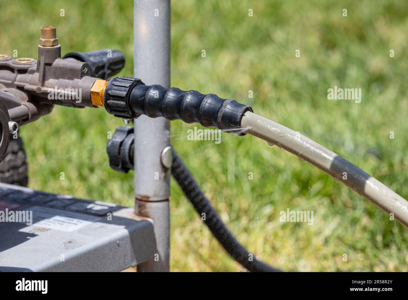 Pressure washer leaking water from high pressure hose. Power washer repair, maintenance and service concept. Stock Photo