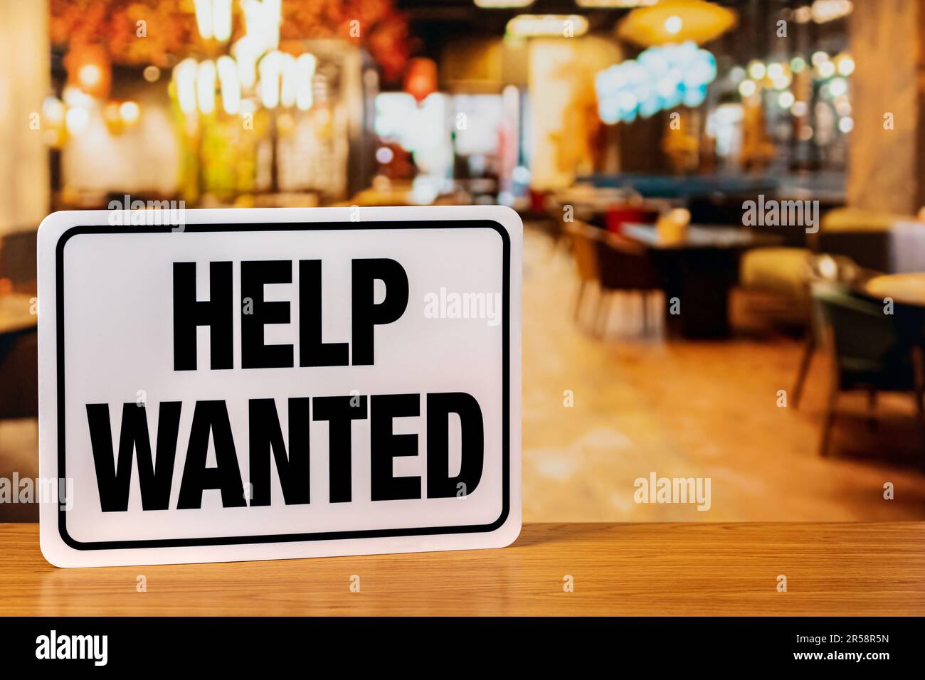 Help wanted sign inside restaurant. Food service industry jobs, labor shortage and unemployment concept. Stock Photo