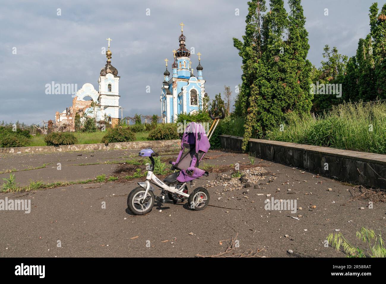 View of destroyed Church of the Holy Mother with baby carriage on foreground in village of Bohorodychne in Donetsk region by Russian forces during occupation from August 2022 until September 2022. Russian forces attacked the village in May 2022 and finally occupied the village in August for 2 months, it was liberated in September 2022. From the hills surrounding the village Russian forces shelled and destroyed homes, school and the famous Church of the Holy Mother of God ‘Joy of All Who Sorrow'. The church became a convent of the Sviatohirsk Lavra in 2008. The church belongs to the Ukrainian O Stock Photo