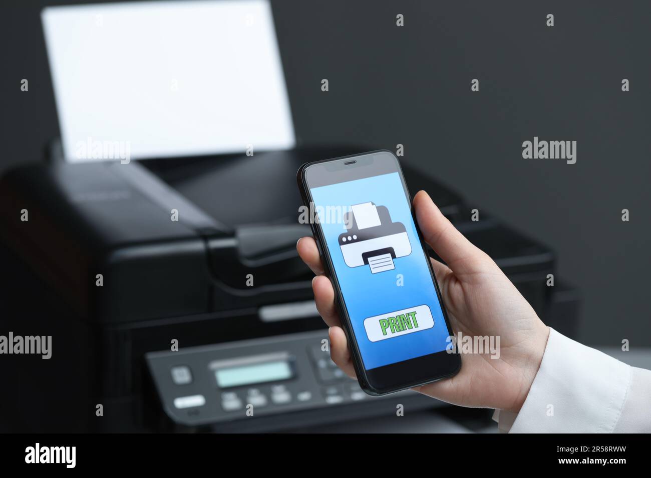 Man using printer management application on mobile phone indoors, closeup and space for text Stock Photo