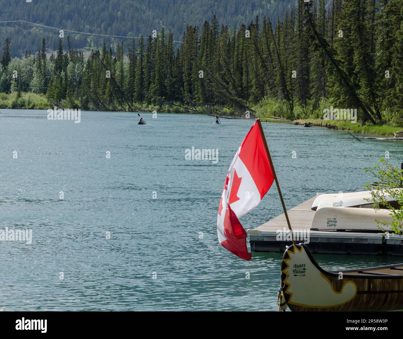 Two canoeists paddling near the Banff Canoe Club on the Bow River in Banff, Alberta. Stock Photo
