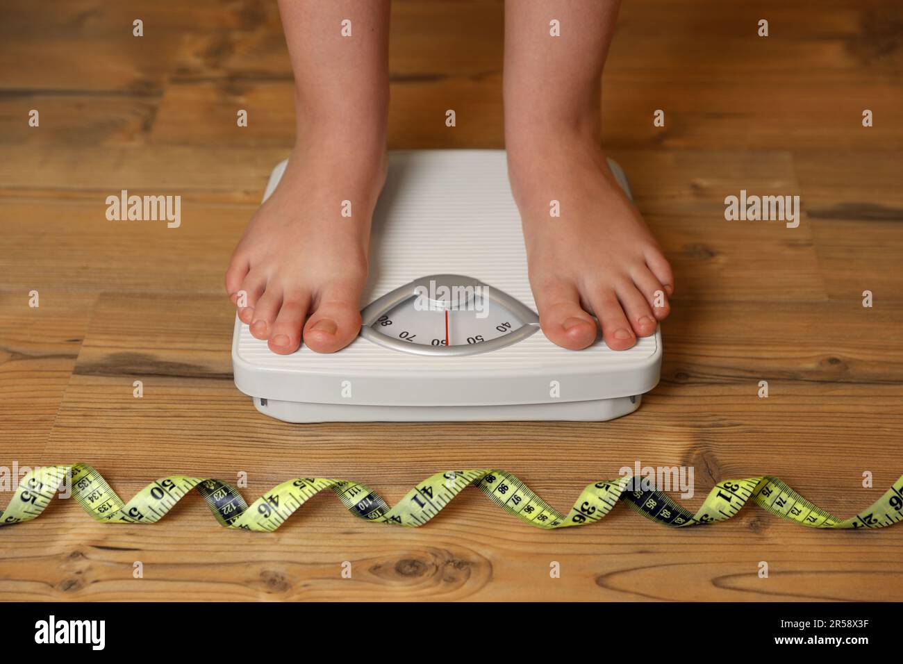 Overweight child scales measuring tape hires stock photography and