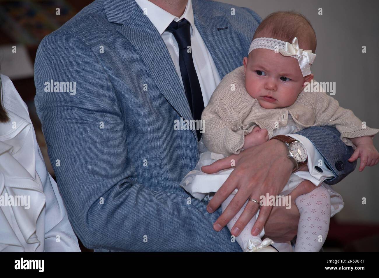 Midsection of father holding his baby girl in a church ready for christening Stock Photo