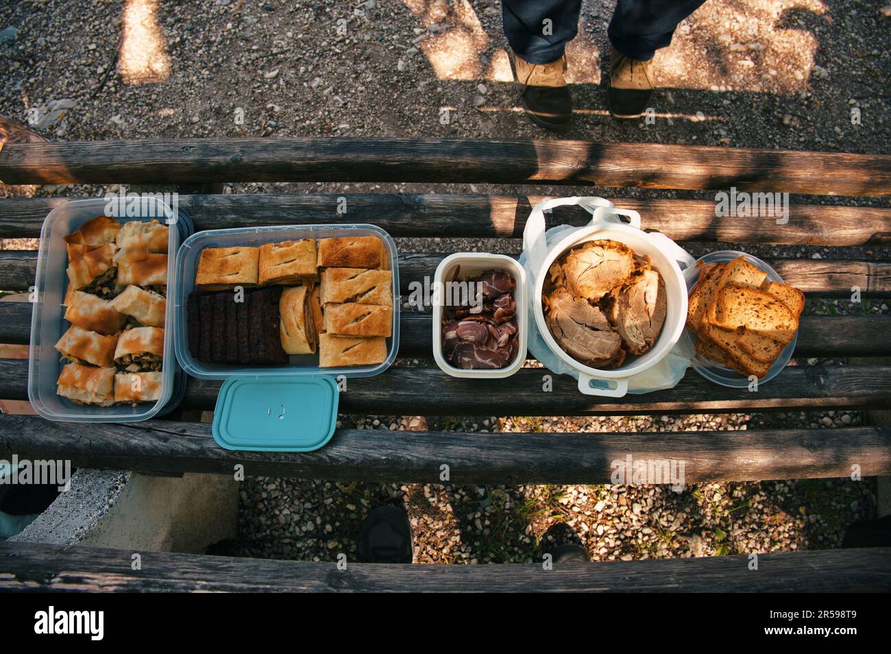 A top view photo of assorted foods on a wooden park bench Stock Photo