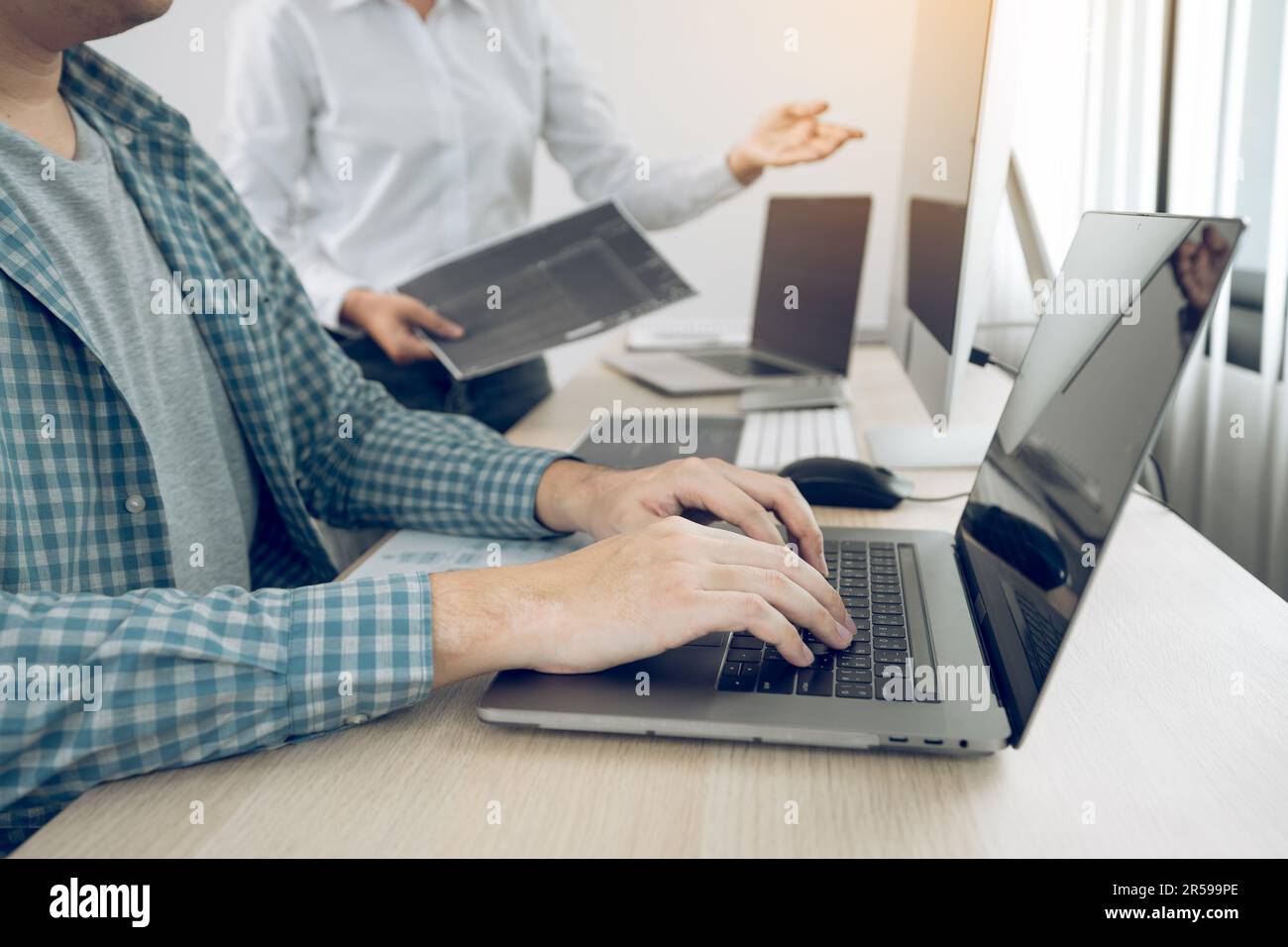 Two partnerships developing programming and coding technologies working on laptop and analyzing together. Stock Photo