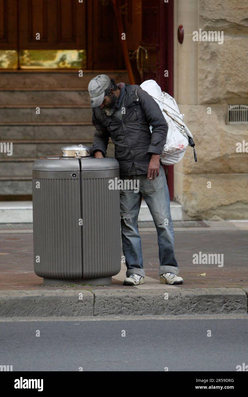 A homeless man rummages through a garbage bin on Macquarie Street in ...