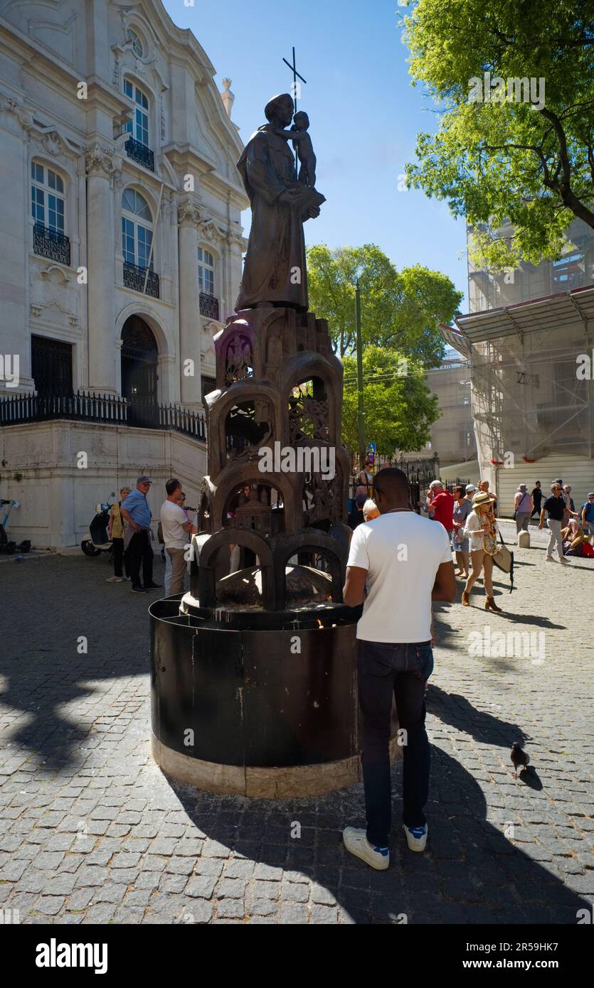 Candles being lit outside Lisbon's Sé Cathedral on a statue of St Anthony Stock Photo